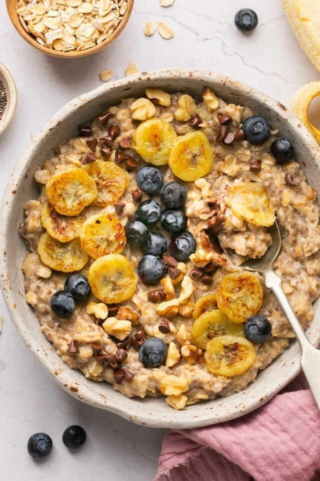 Warm oatmeal bowl with caramelised banana, blueberries and walnuts